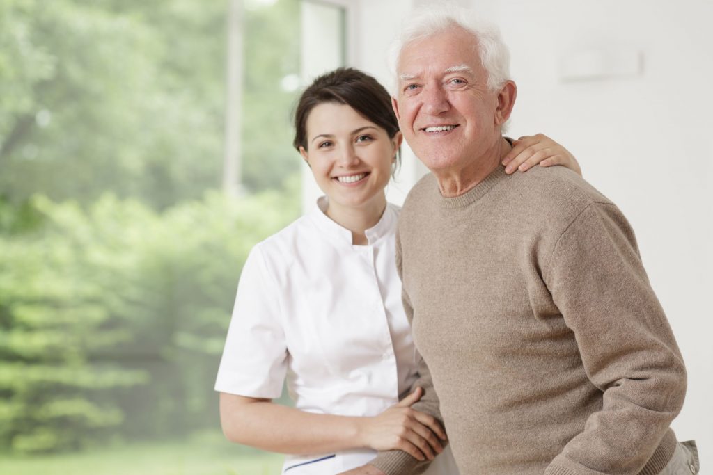 Young nurse taking care of old sick man